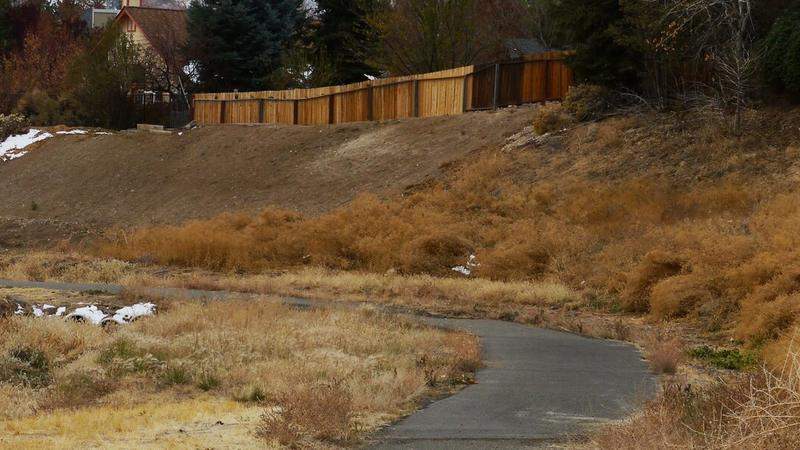 Человек идёт по жаркой летней улице с бутылкой воды в руке