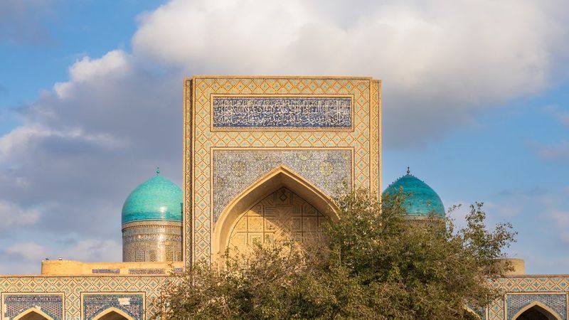 Семья гуляет по историческому центру Бухары рядом с Ляби-Хауз