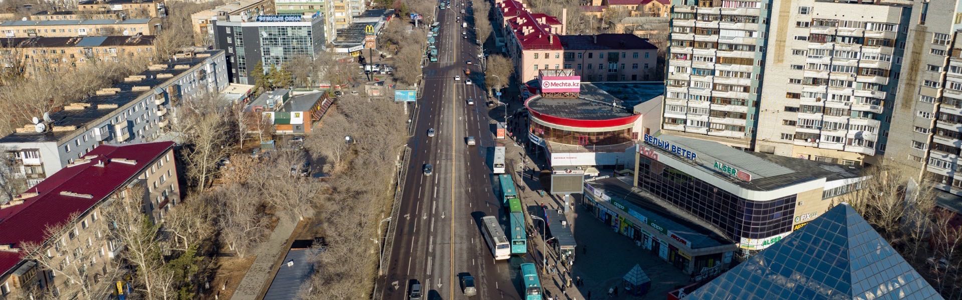 Площадь в районе Новый город Караганды весной — пятиэтажные «хрущёвки», люди и автобусная остановка