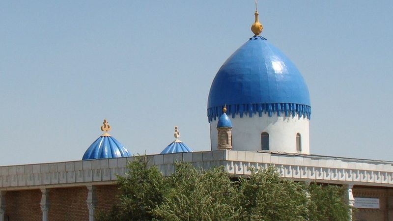 Мечеть Айтбай в Кызылорде — кирпичный минарет и небесно-синие купола над зелёной листвой