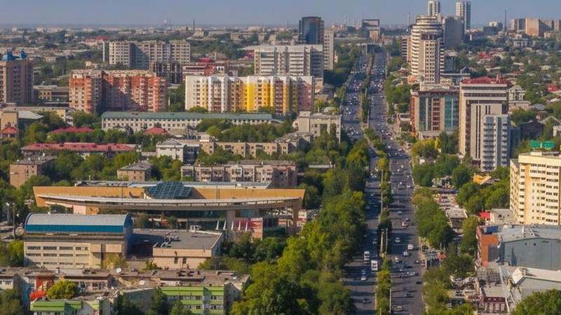 Шымкент с высоты — широкая улица проспекта Тауке хана, кварталы домов и зелёные дворы под летним небом